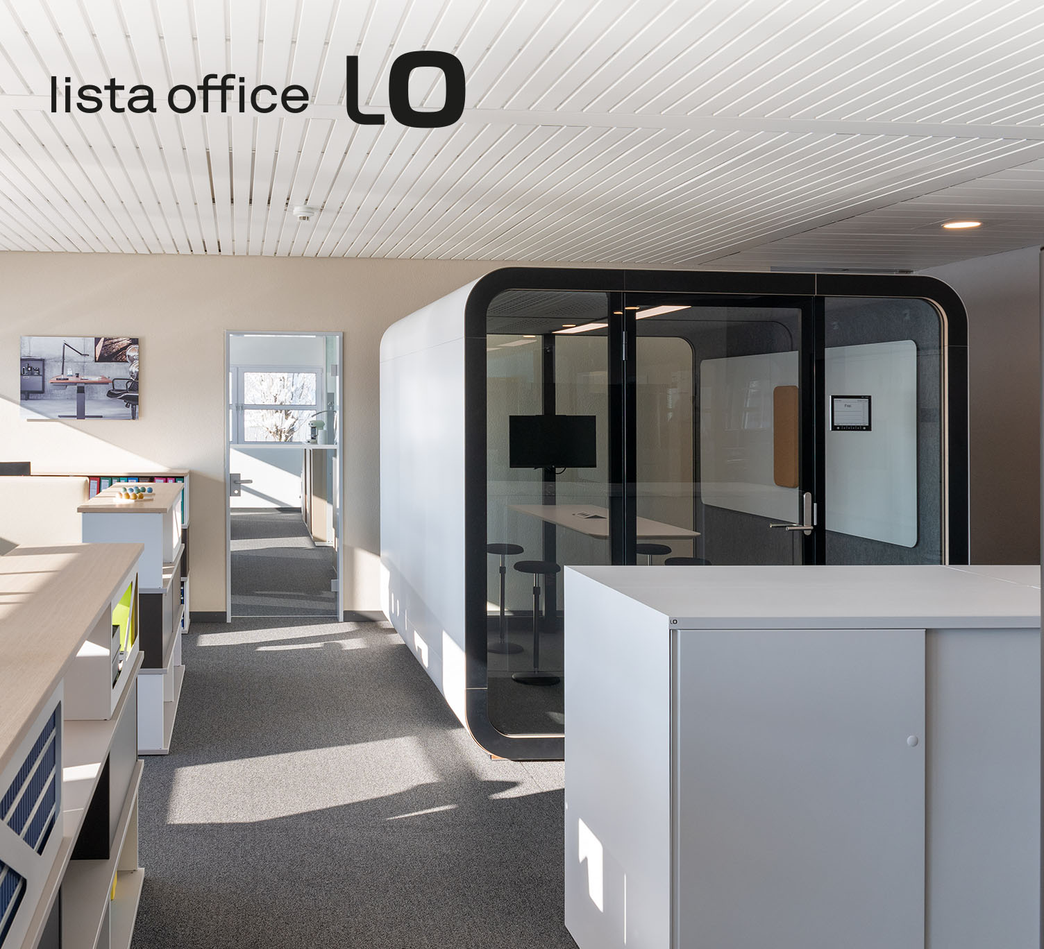 Modern gestaltetes Büro mit Glas-Meetingbox, minimalistischer Möblierung und dem Logo «lista office LO» oben links im Bild.