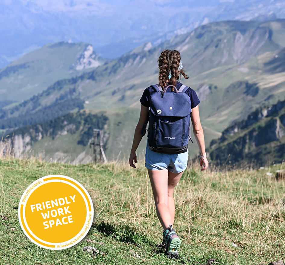 Frau mit Rucksack wandert entspannt durch eine Berglandschaft – symbolisiert flexibles Arbeiten und Work-Life-Balance