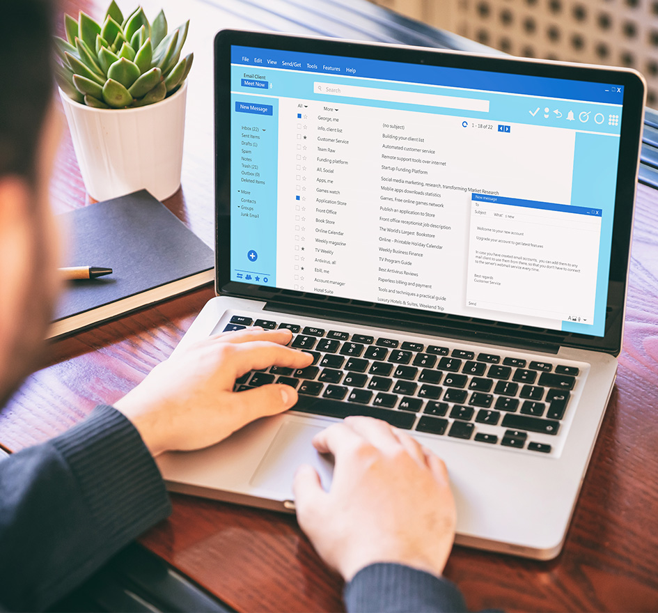 Mann bedient ein Laptop mit geöffnetem E-Mail-Client, auf dem eine Phishing-E-Mail geöffnet ist – symbolisiert das Risiko von Cyberangriffen durch unachtsames Verhalten am Arbeitsplatz.